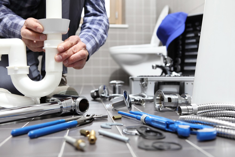 Man fixing the pipe with plumbing instruments